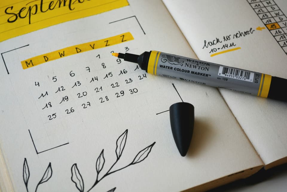 A hand-drawn monthly planner with a marker on it